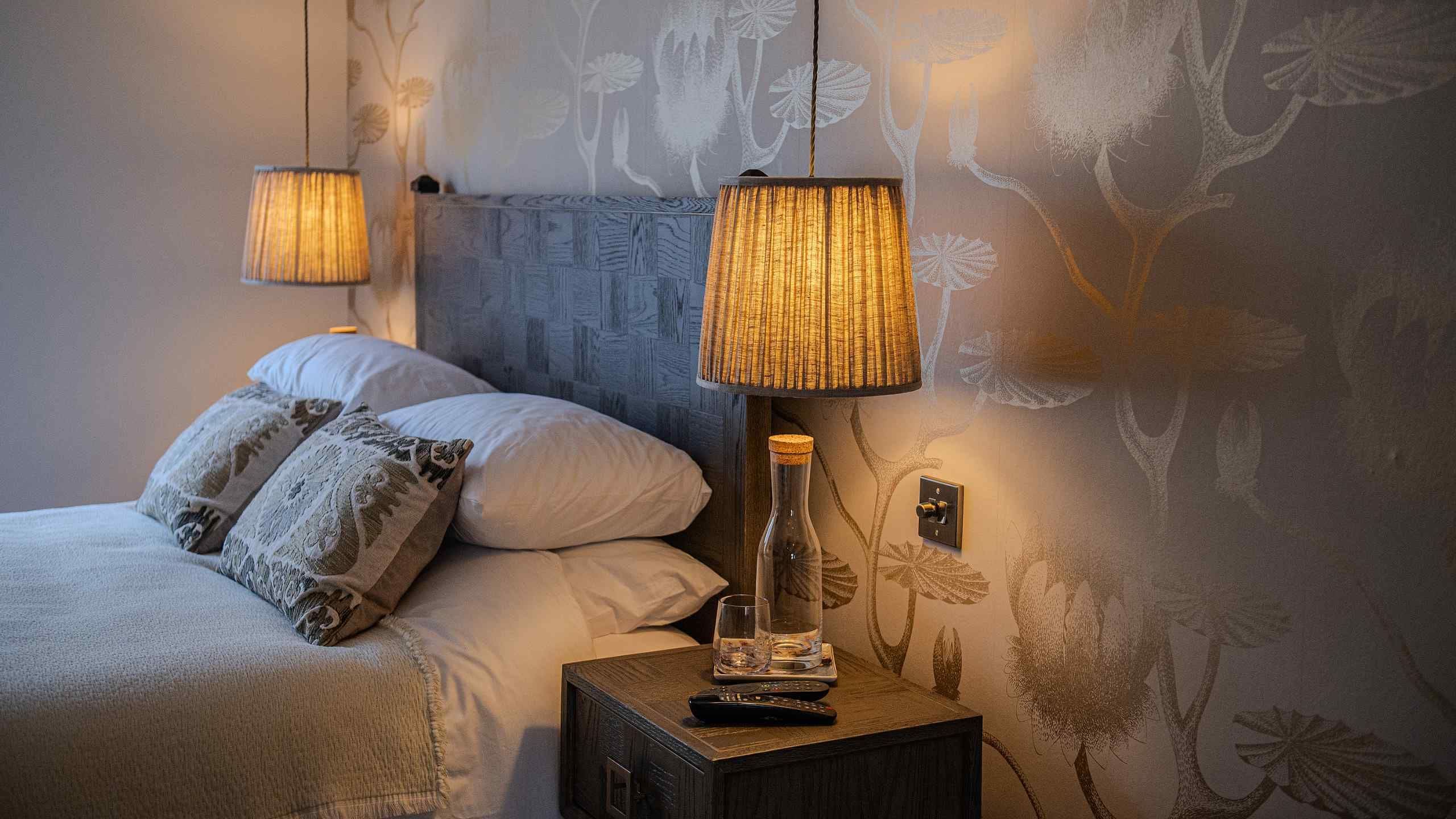 Close-up of a cosy bed with a side table and warm lighting at 15 Albion Street, Broadstairs.